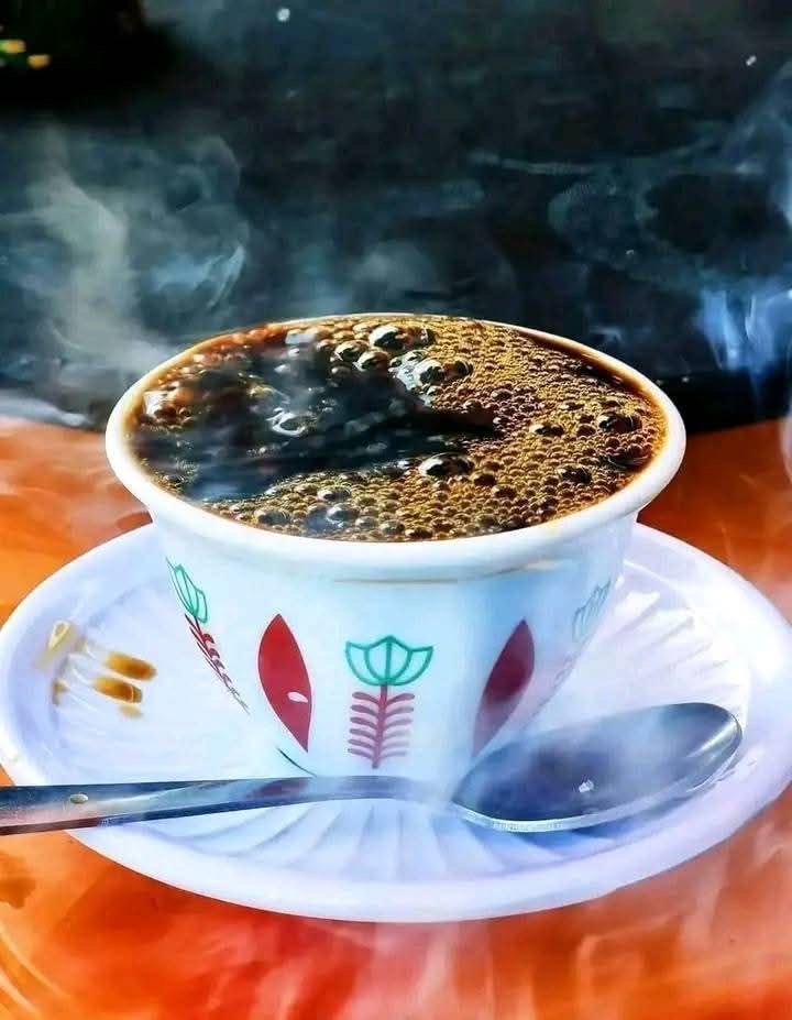 Steaming cup of Ethiopian buna coffee in a painted cup and saucer